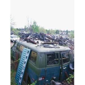  Old Tires and Debris Piled around Decaying Green Van in 